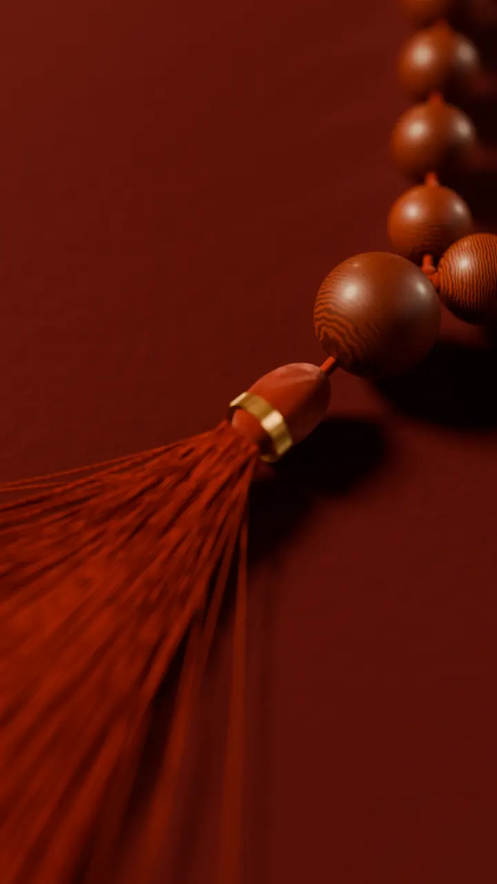The sumeru and tassel of a red sandalwood mala
